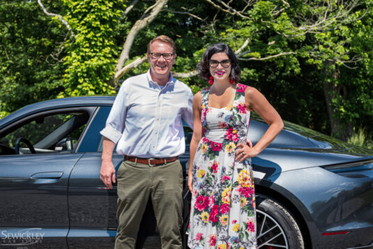 Couple posing by Porsche EV